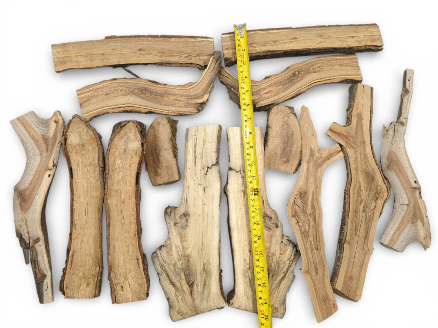 A top-down view shows various split wood logs with a yellow measuring tool for scale comparison.
