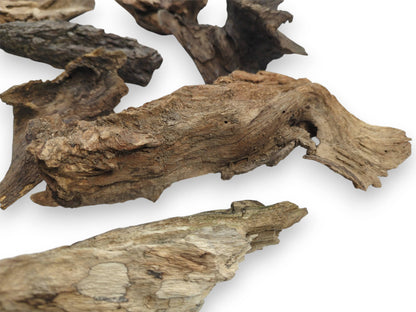 A detailed, angled shot of multiple raw wood chunks, highlighting their rugged and fibrous surface details.