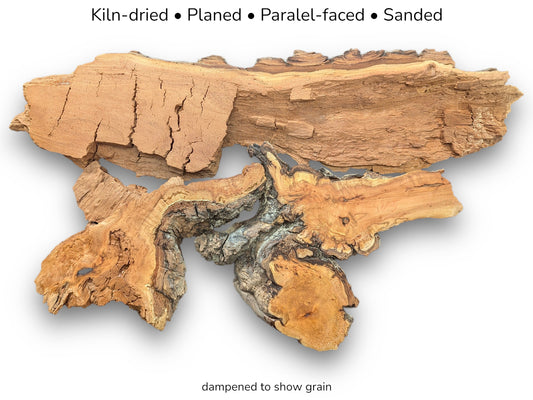 A long, cracked timber slab contrasts two dampened, gnarled burls with swirling golden grain.