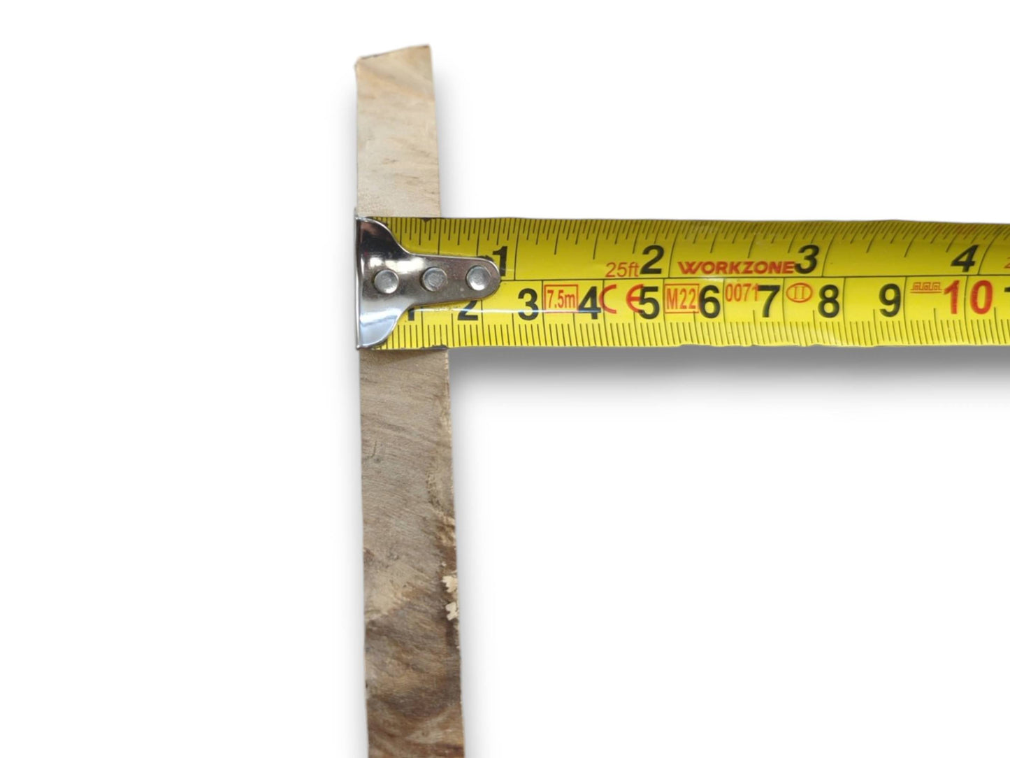 A light-colored elderberry wood piece with a natural edge measured by a yellow tape.