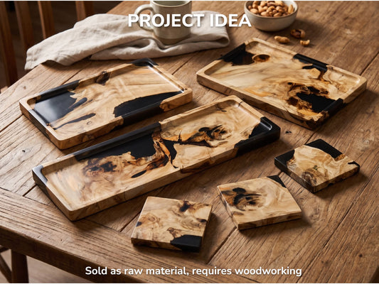 Various elderberry wood pieces with natural edges and black epoxy resin on a wooden table.