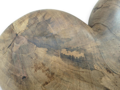 A central knot with radiating cracks anchors the circular grain of a smoothly finished timber heart.