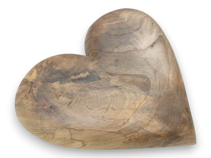 A thick, heart-shaped piece of walnut displays swirling grain patterns and dark, cloudy blotches.