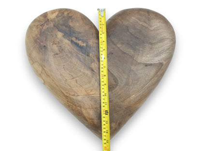 A yellow tape measure shows the height of a carved walnut heart with dark, smoky grain.