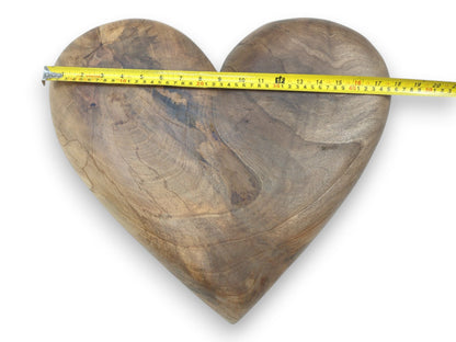 A measuring tape stretches across a timber heart, showing its width over undulating grain.
