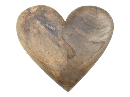 A carved timber heart, shot head-on, displays sweeping grain and dark, smoky mineral figuring.