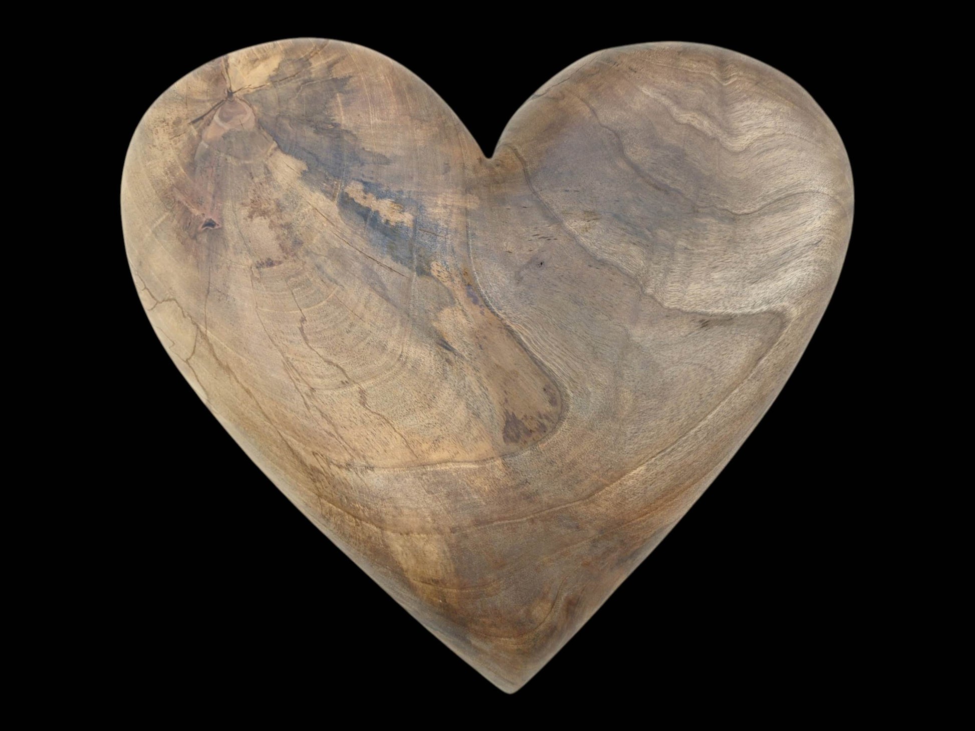 Fine fissures and dark, smoky patches mark the sweeping grain of a carved walnut heart.