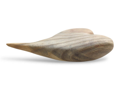 From a low angle, a sculpted heart shows undulating bands of grain and an elongated tip.