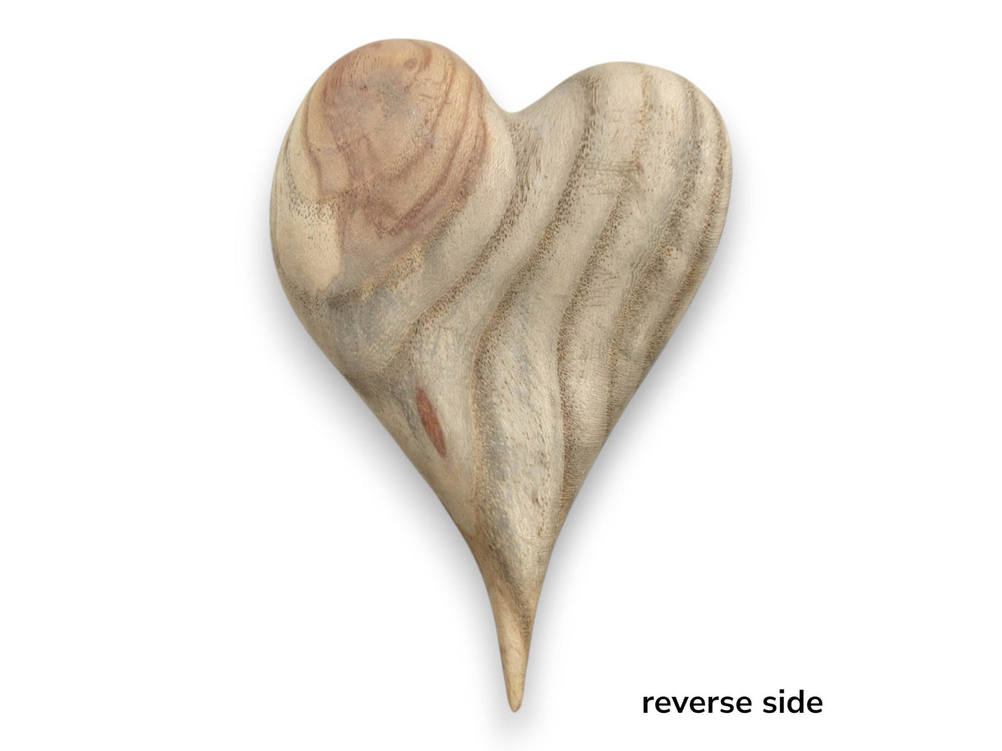 A heart-shaped wood carving features a reddish blush and dramatic, wavy grain across its surface.