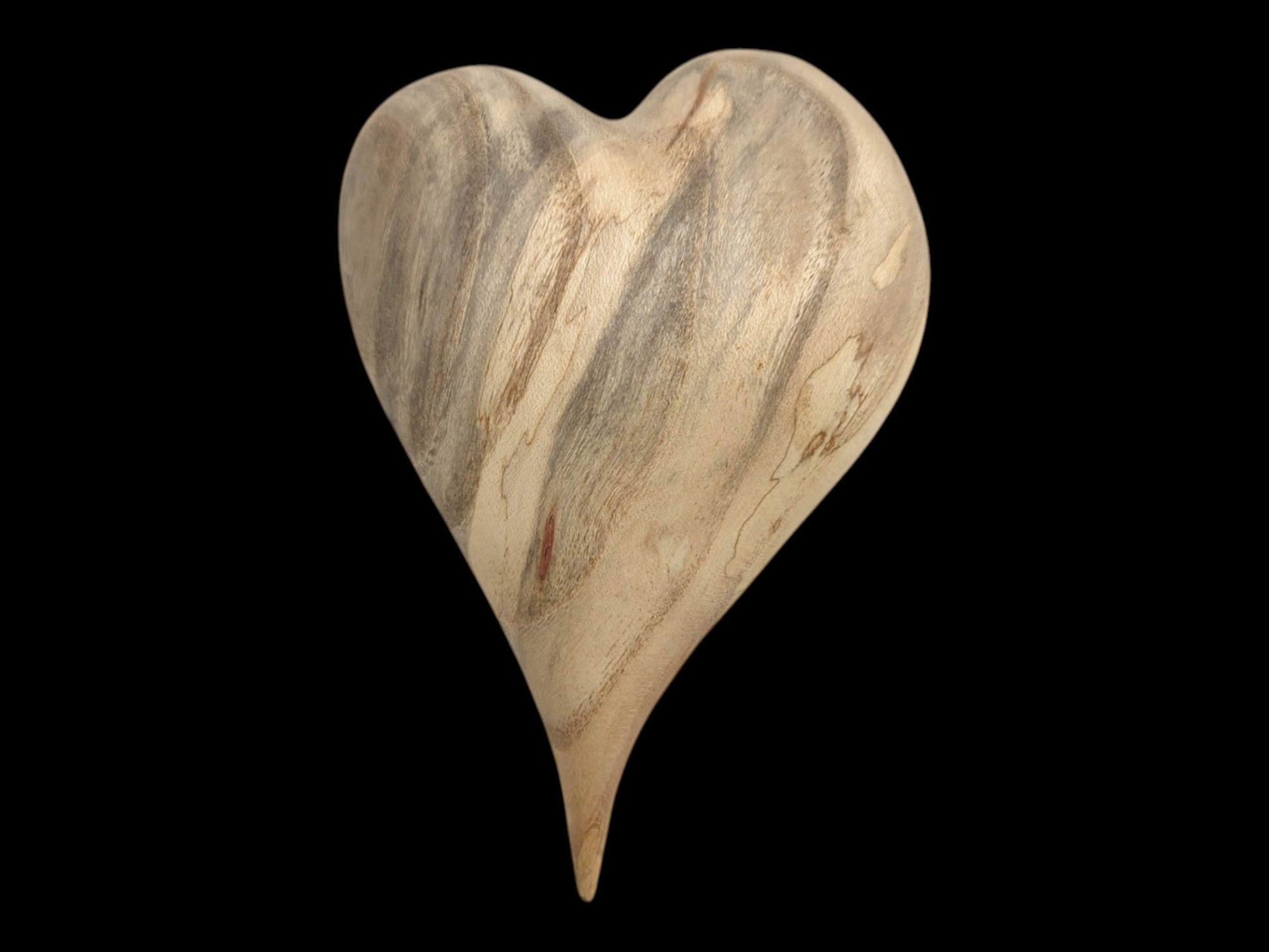 Viewed straight-on, a polished heart carving has vertical gray and brown mineral streaks.