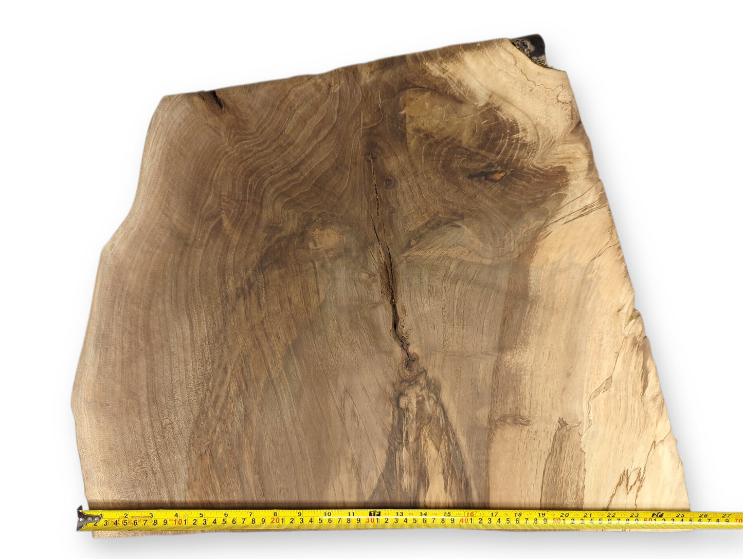 An irregular live edge wood slice, light and dark brown, displays swirling grain and a measuring tape.