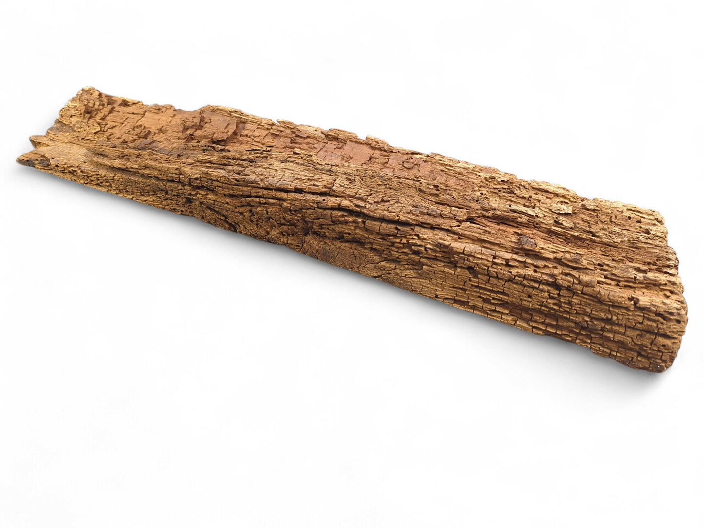 An elongated, rough-hewn brown wood fragment with a deeply grooved, flaking, and crumbly surface.