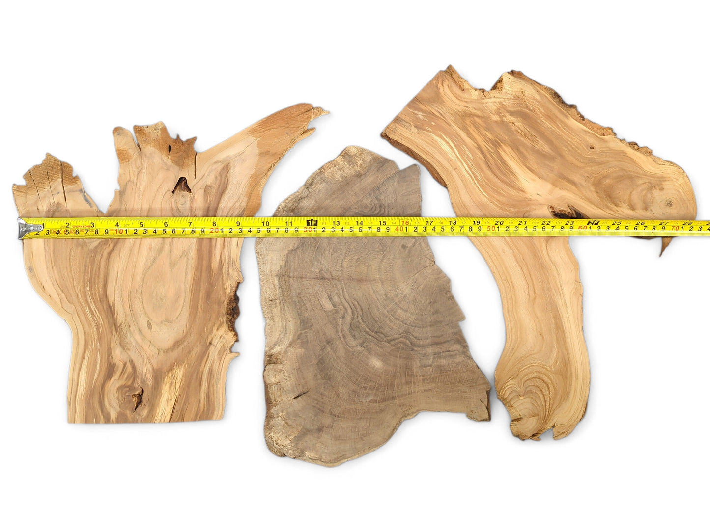 Three mixed, unfinished wood slices featuring varied brown tones, prominent grain, live edges, and a measuring tape.