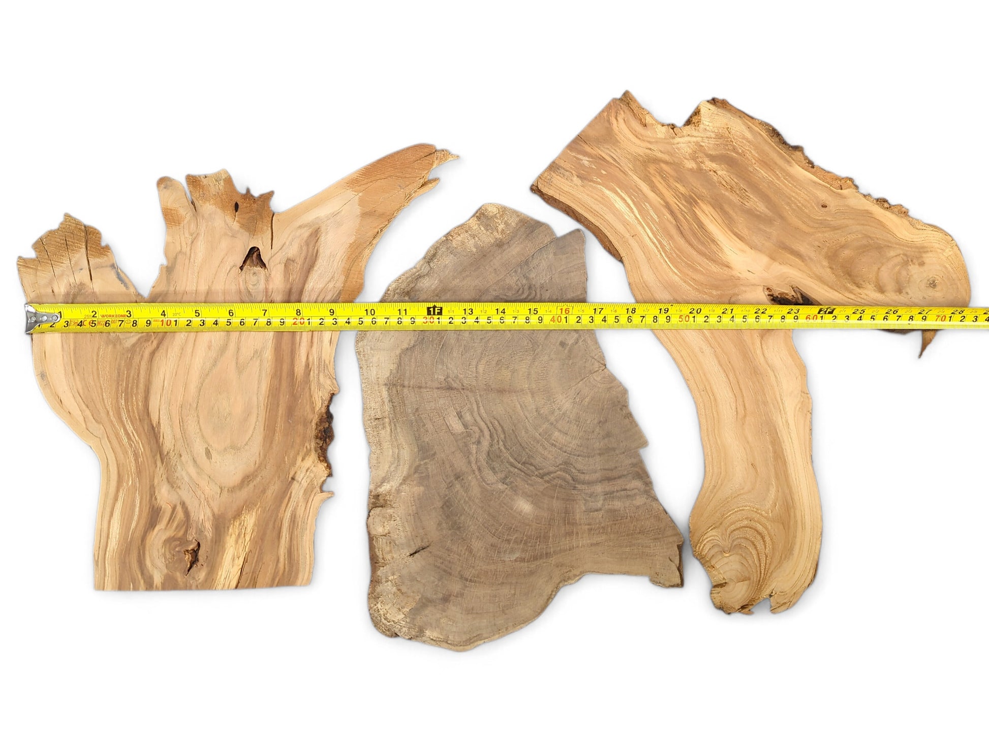 Three mixed, unfinished wood slices featuring varied brown tones, prominent grain, live edges, and a measuring tape.