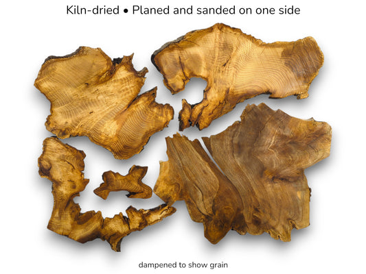 Kiln-dried and planed wood slices, dampened to show the rich, detailed grain patterns.
