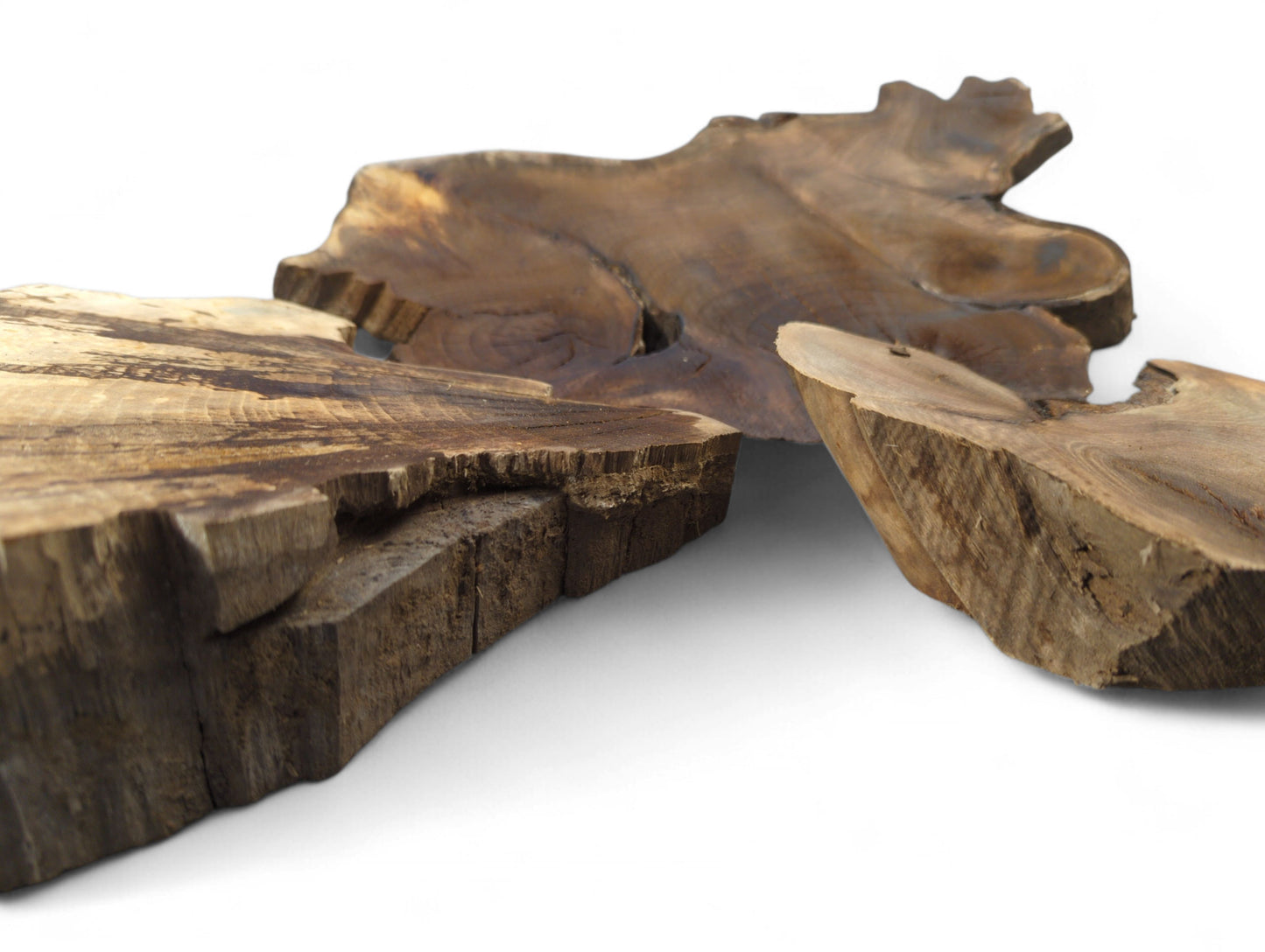 Three irregular brown wood slices, some wedge-shaped, showing natural live edges and grain.