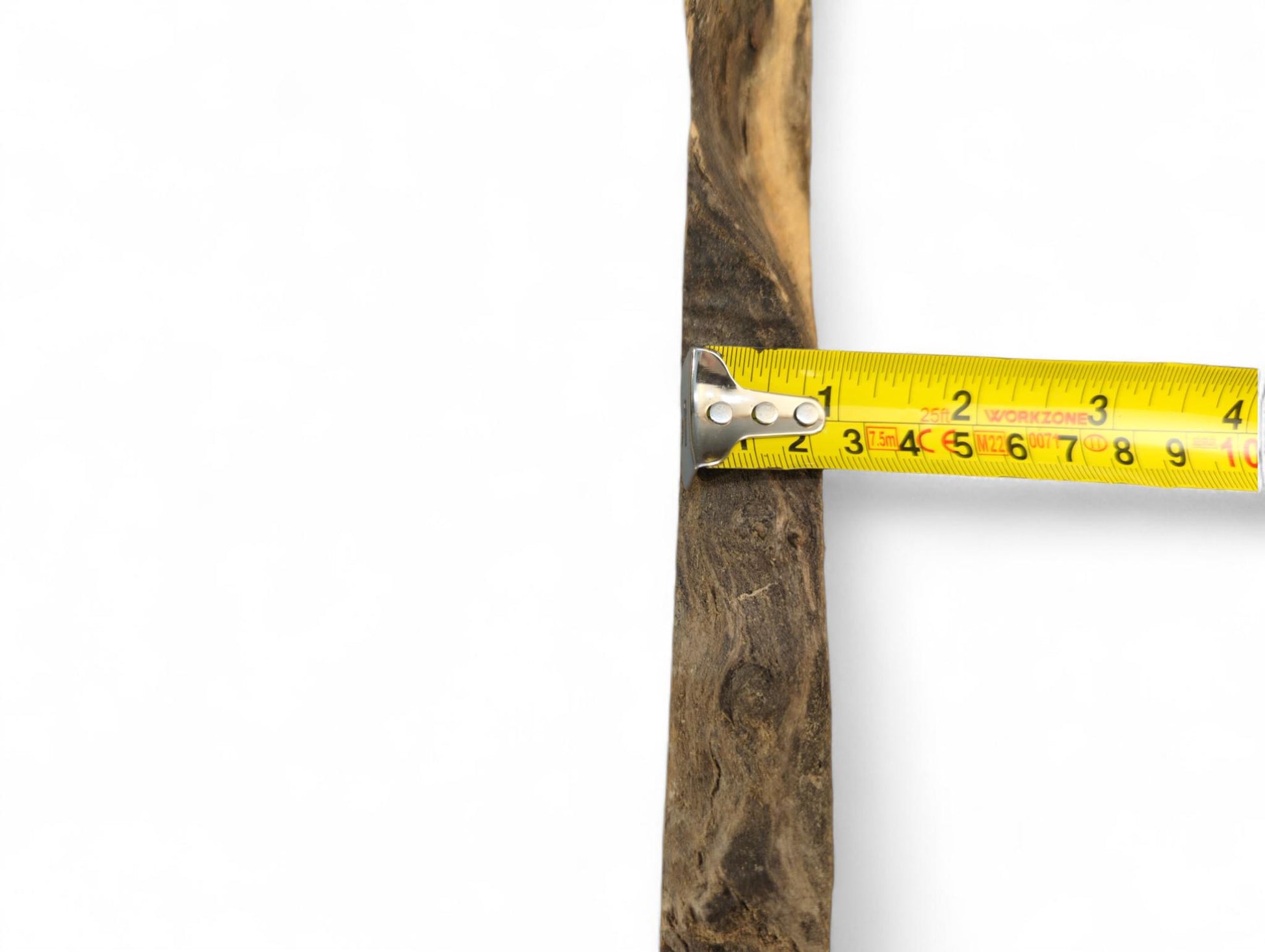 A long, narrow wood piece with dark and light brown grain, measured by a yellow tape.