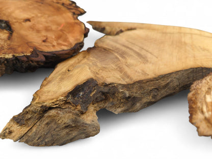 Unfinished, naturally shaped wood pieces with live edges, displaying varied grain and dark bark.