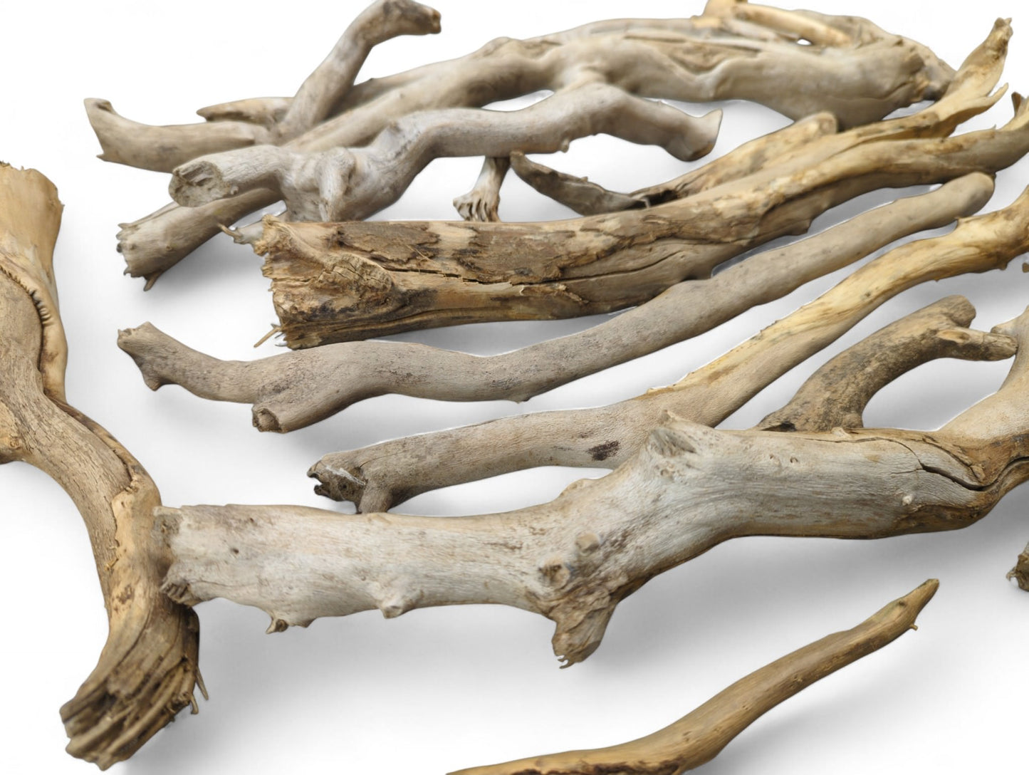 Collection of natural weathered driftwood sticks displaying various shapes and textures, in light brown, gray, and beige.
