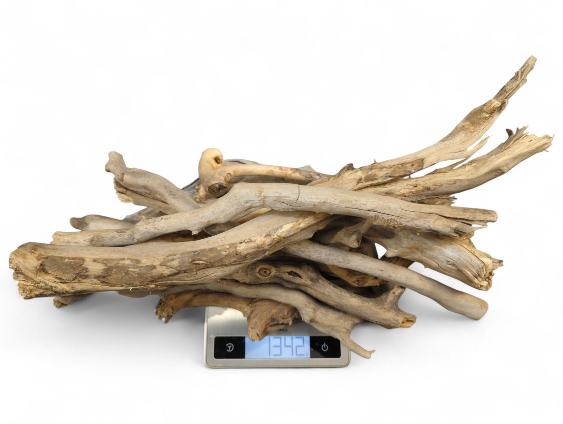 Varied natural driftwood sticks in light brown and gray, piled on a digital scale displaying '1342'.