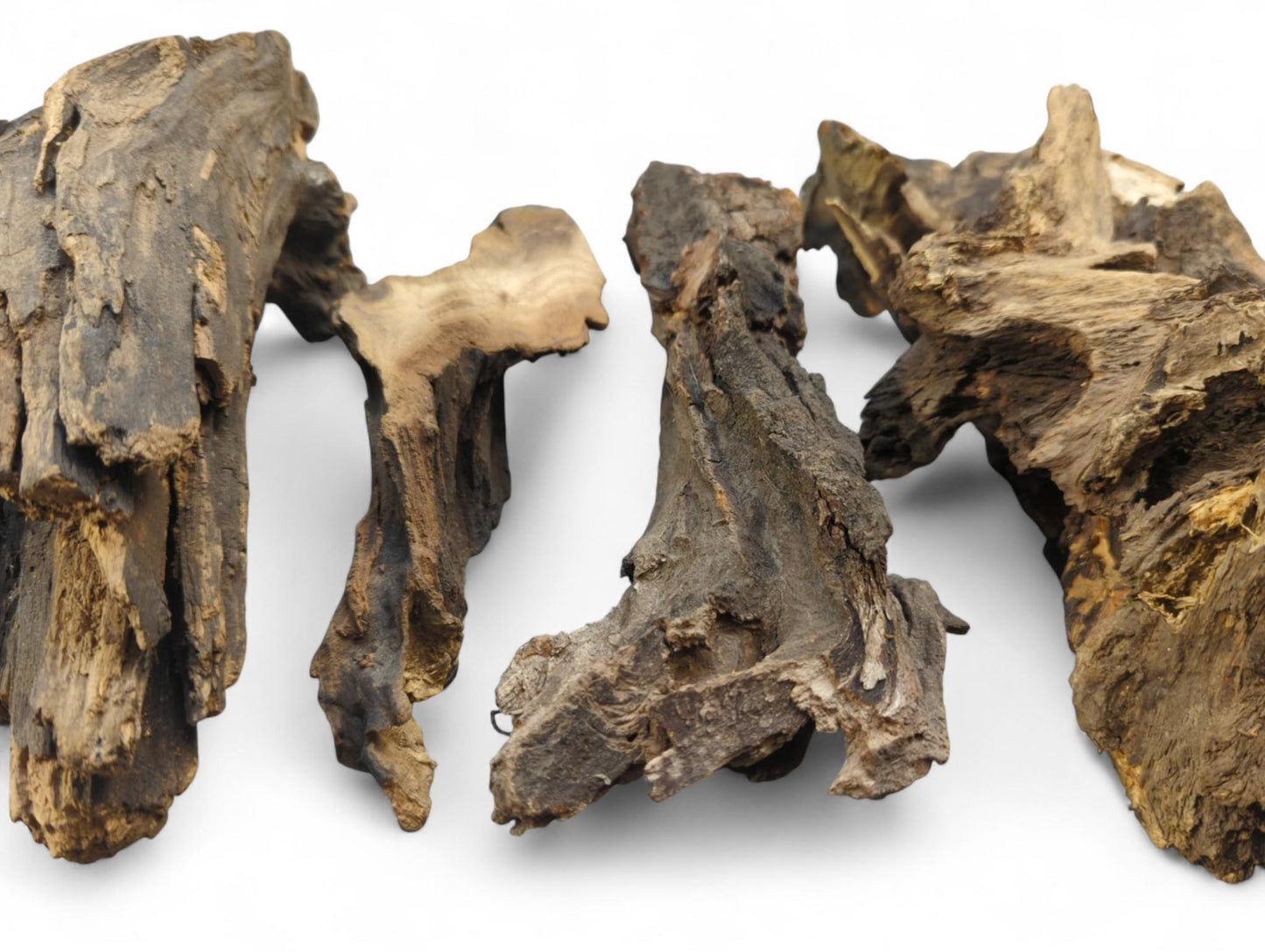 Four gnarled, irregular pieces of dark brown aged wood, featuring rough textures and lighter grain.
