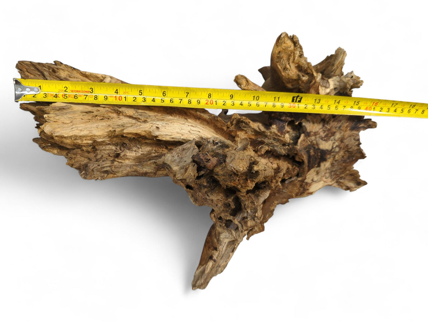 Distressed natural wood with jagged edges and a rough, textured surface, measured by a yellow tape.