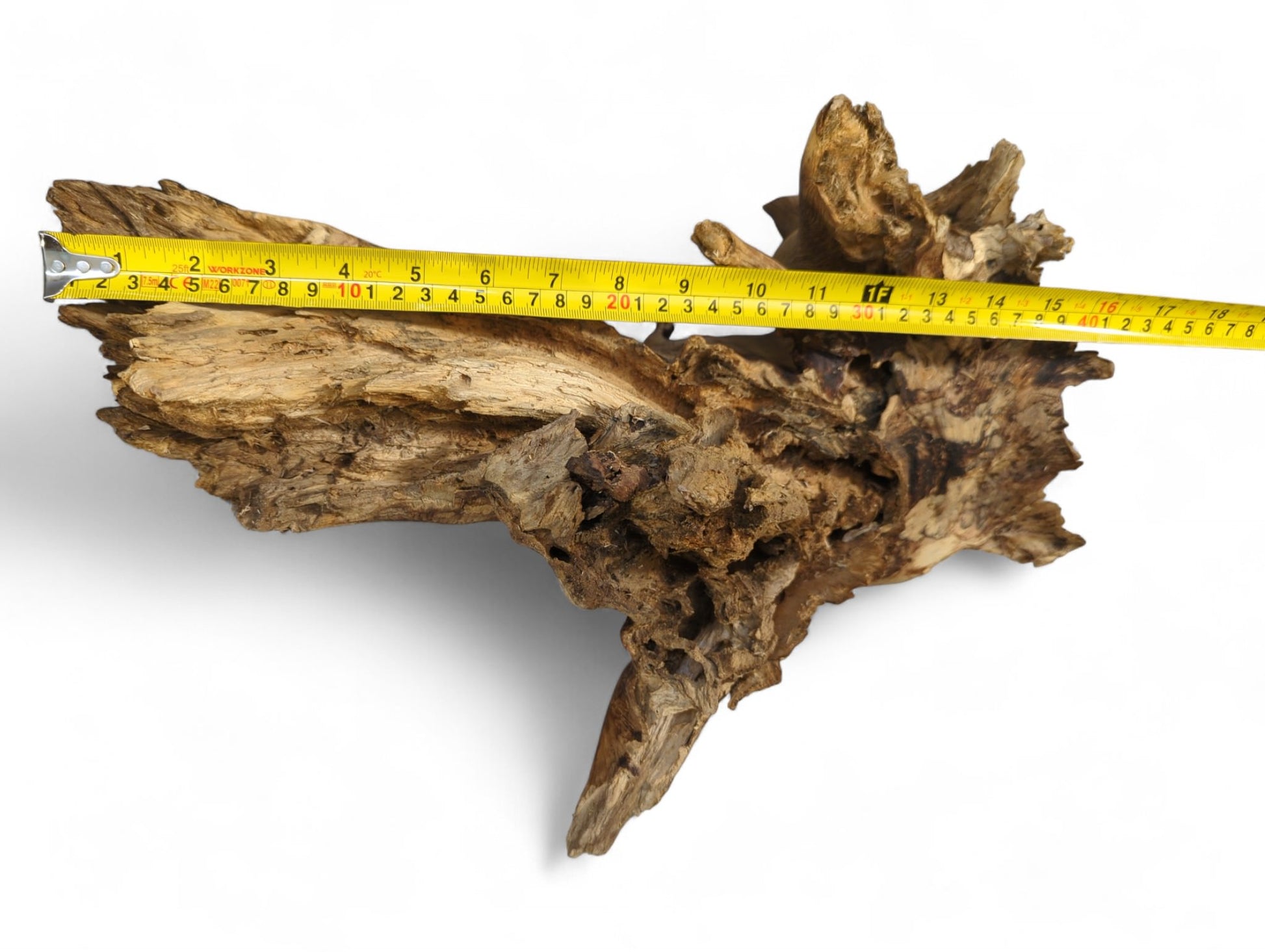 Distressed natural wood with jagged edges and a rough, textured surface, measured by a yellow tape.