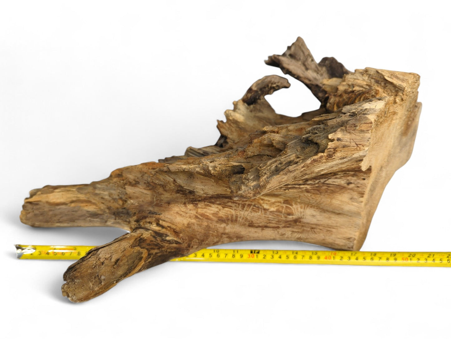 Natural wood piece, irregular brown tones, rough texture, visible grain, with yellow measuring tape.