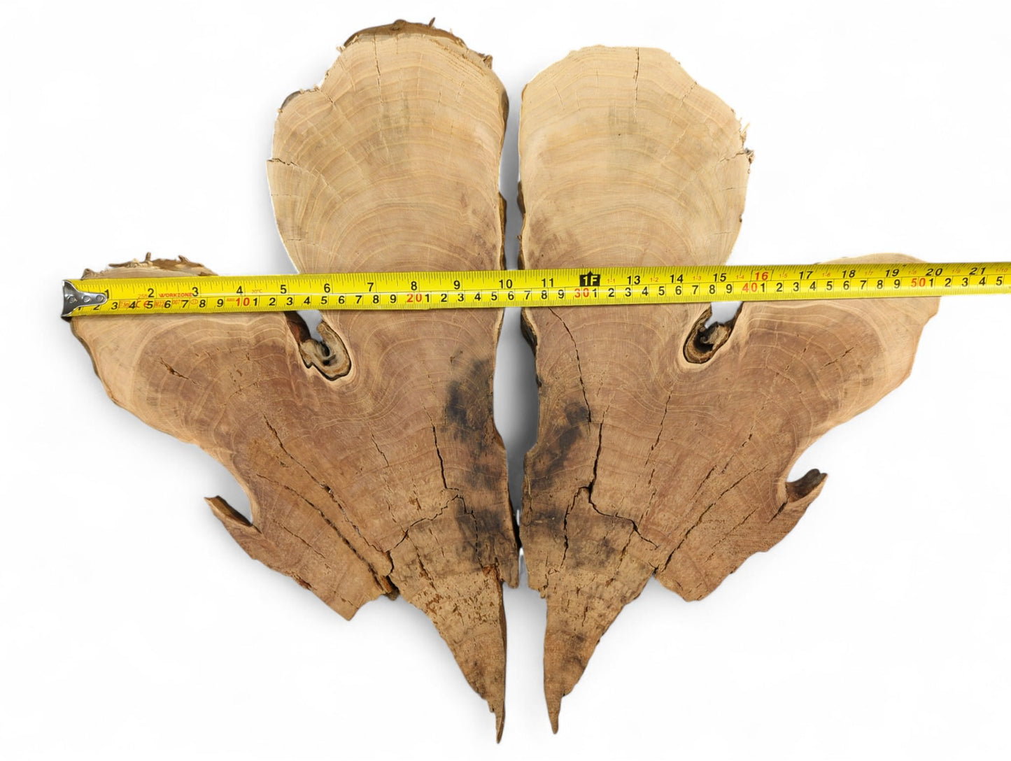 Brown bookmatched wild cherry wood slices with live edges, visible grain, and cracks, measured by a yellow tape.