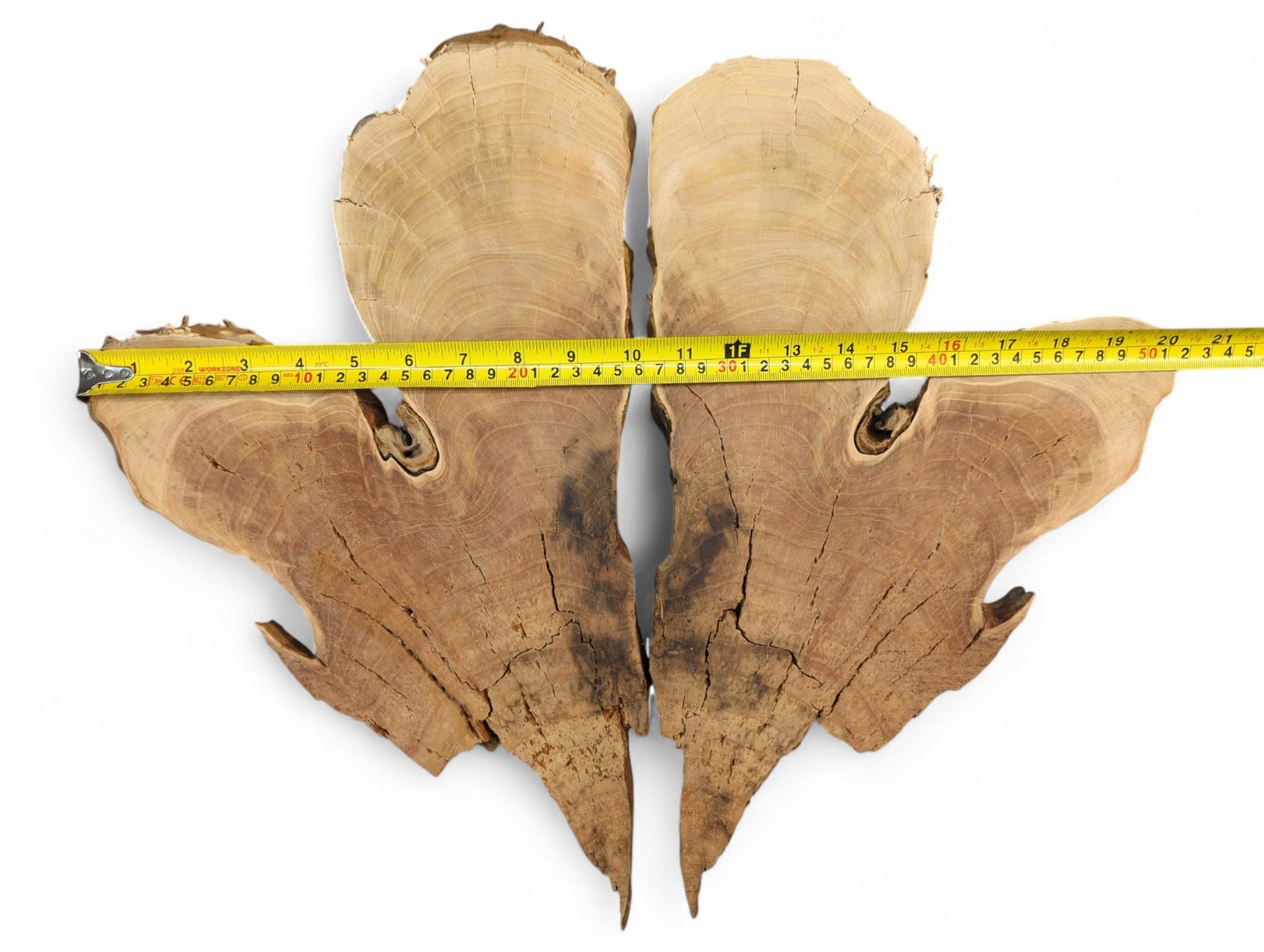 Brown bookmatched wild cherry wood slices with live edges, visible grain, and cracks, measured by a yellow tape.