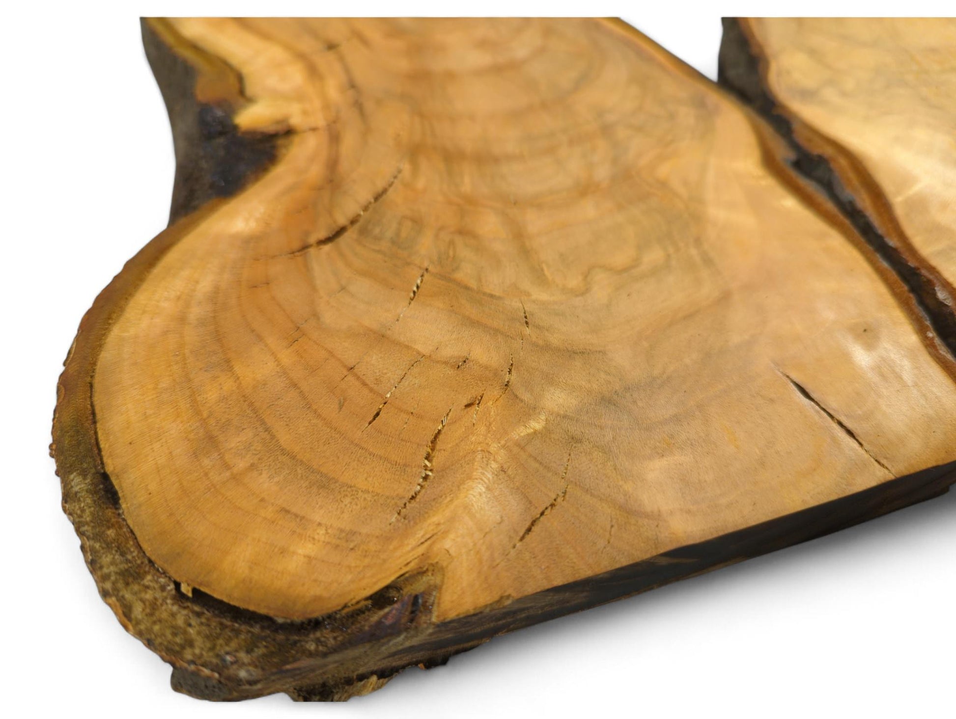 Golden-orange wild cherry wood slice, showing an irregular live edge, visible annual rings, and surface cracks.