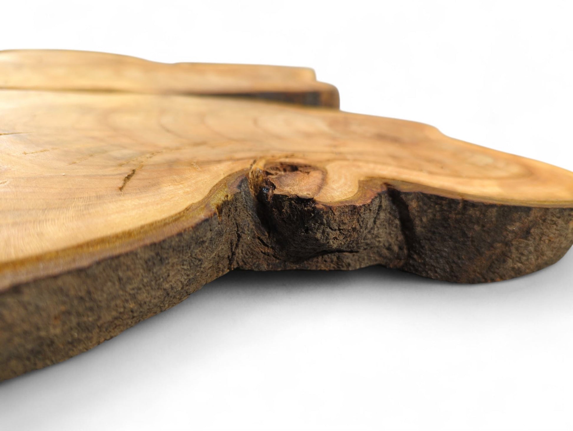 Irregularly shaped wild cherry wood slice, light golden-brown, with a dark, rough live bark edge.