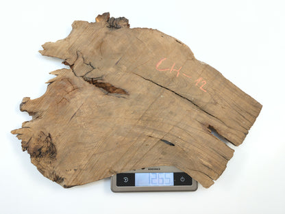 A raw, irregular wild cherry slab marked CH-12 is placed on a digital scale showing its weight.