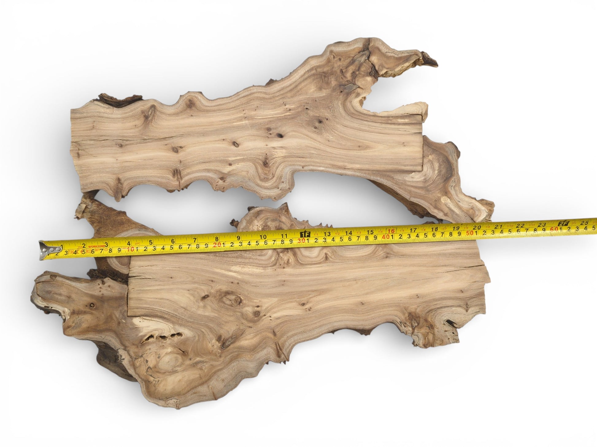 A direct overhead view of two wood sections with a yellow tape rule measuring their span.
