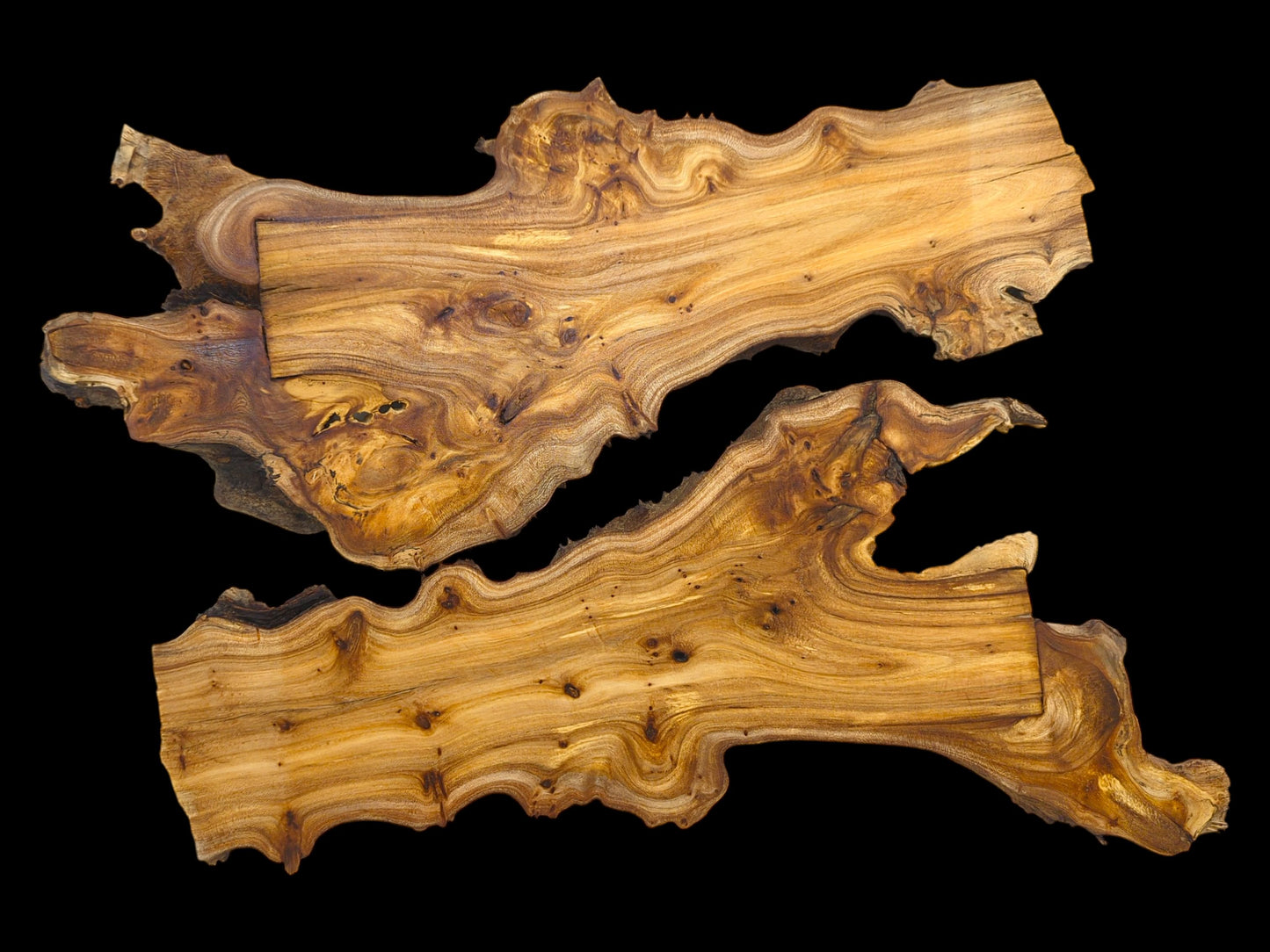 Two irregularly shaped wood pieces displaying prominent, wavy grain patterns against a solid black background.