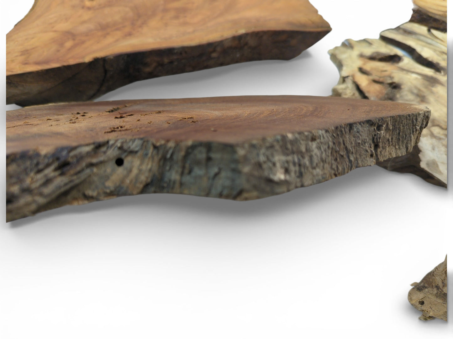 A low-angle shot displays the coarse texture of a dark brown wood slab's substantial edge.