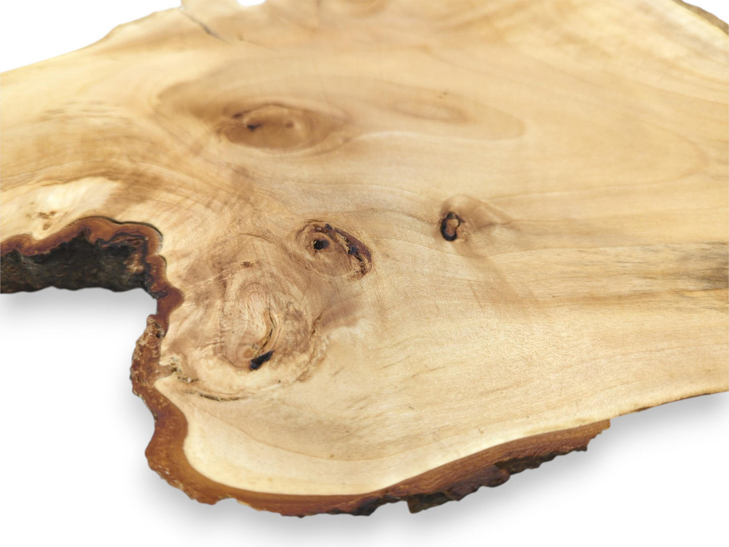 Sweeping grain patterns on a pale wood slab swirl around several dark, hollowed-out knots.
