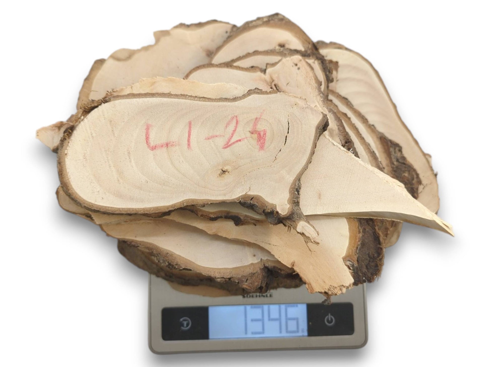 A pile of natural linden wood slices with bark edges on a digital scale.