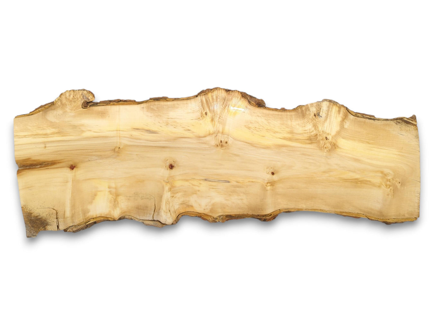 An overhead view of a long, pale wood plank with undulating live edges and knots.