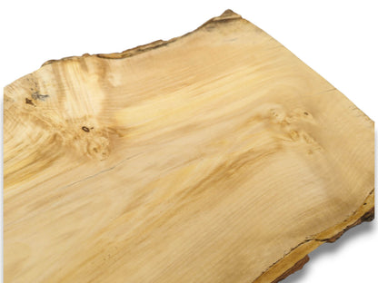 A diagonally viewed timber slab reveals a swirling grain, bird's-eye knots, and a dark bark rind.