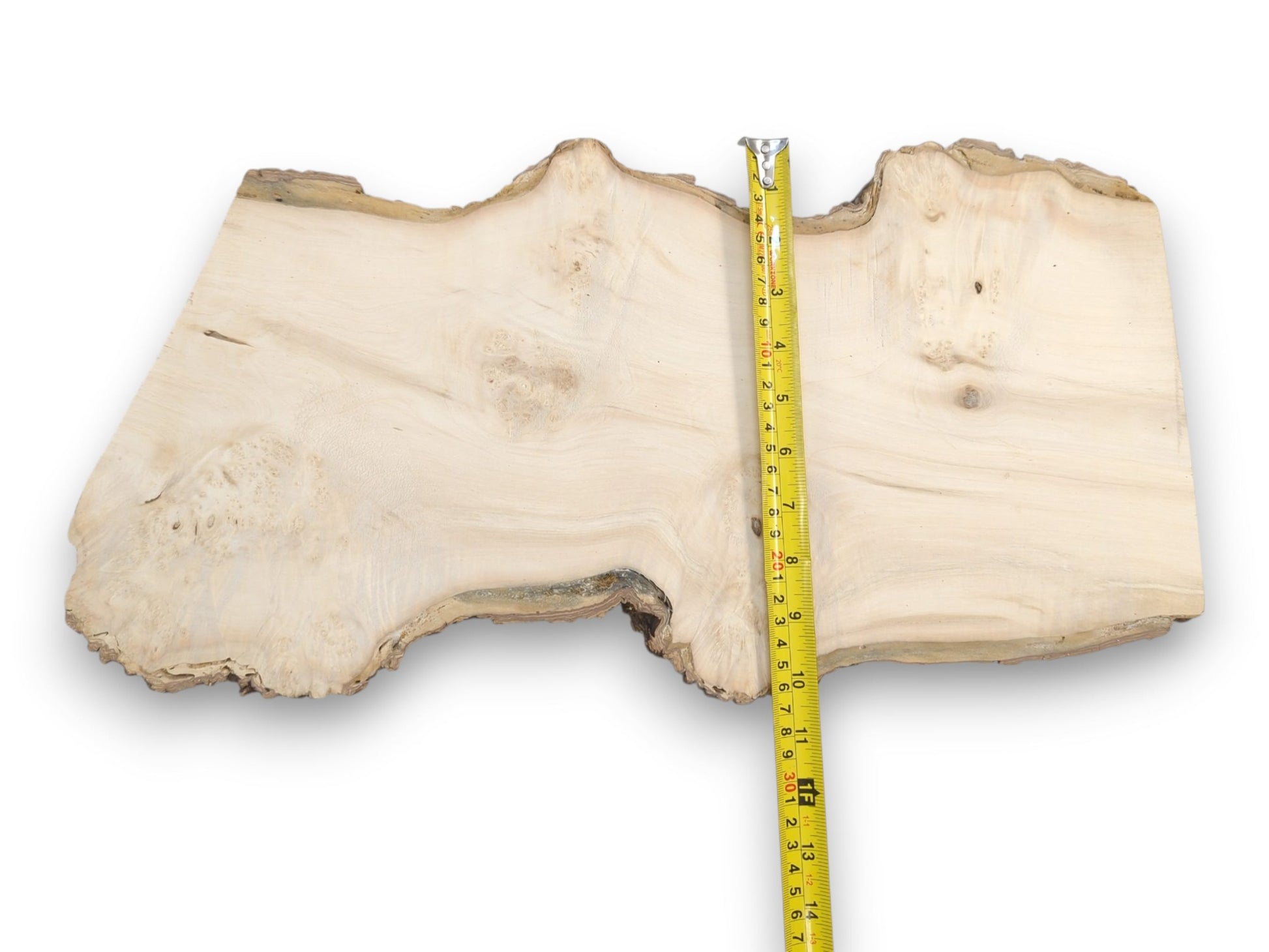 A pale wood slab with wavy grain and a natural edge, measured for width.