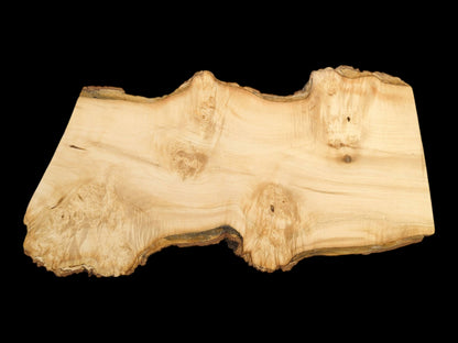 A light-toned woodcut with a contoured, bark-covered border shows swirling grain and knotting.
