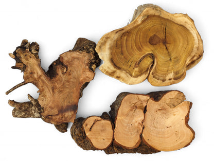 A set of three light-colored, irregular wood slices, planed, sanded, with rough, dark bark.