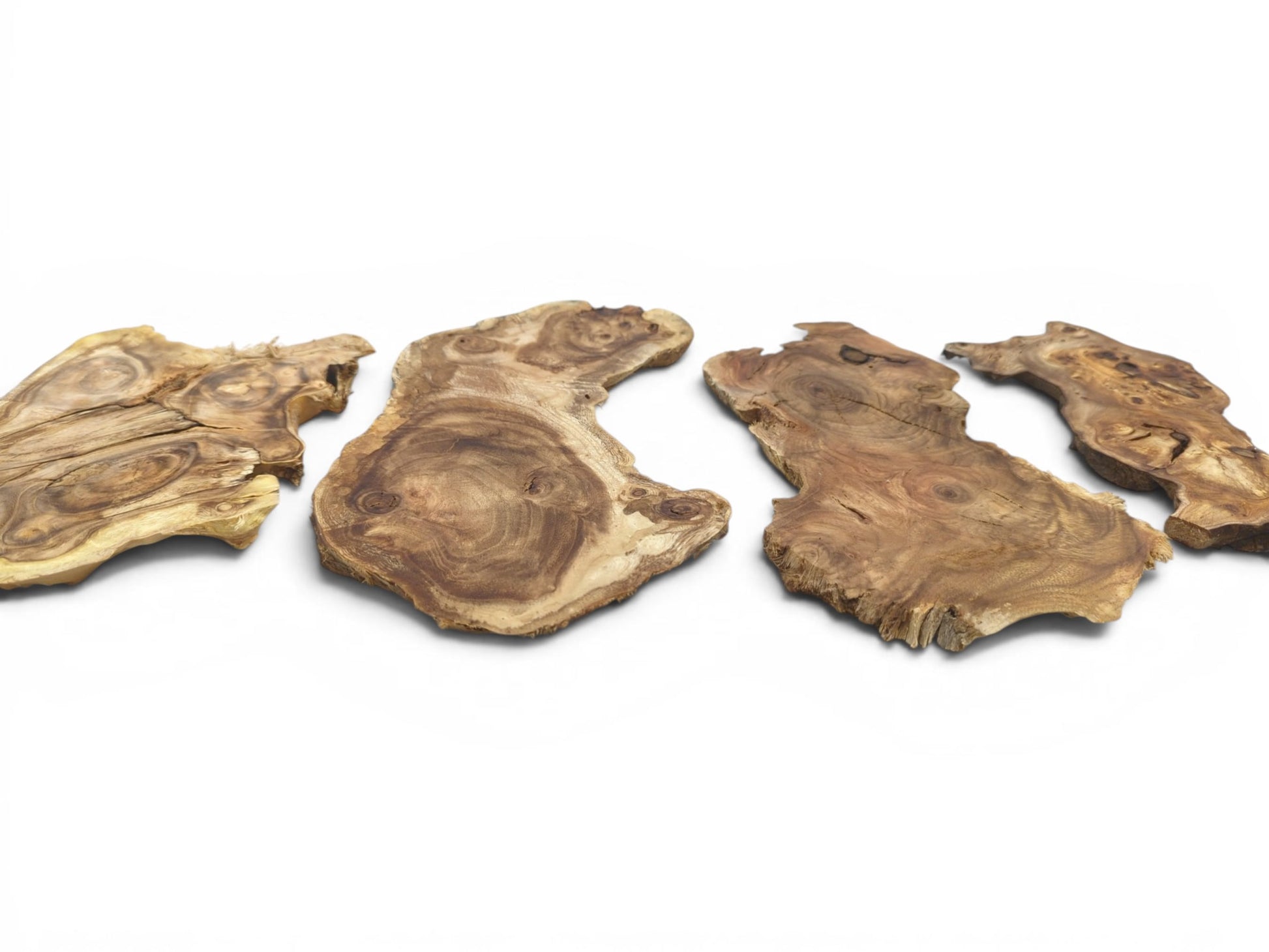 Four irregularly shaped, light brown wood slices with visible grain, knots, and cracks on white.