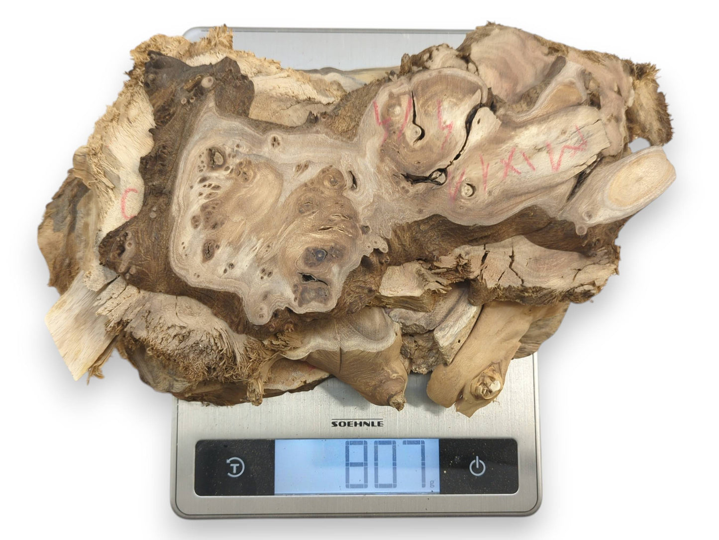 Top-down view of multiple irregular mulberry wood pieces with natural edges on a scale.