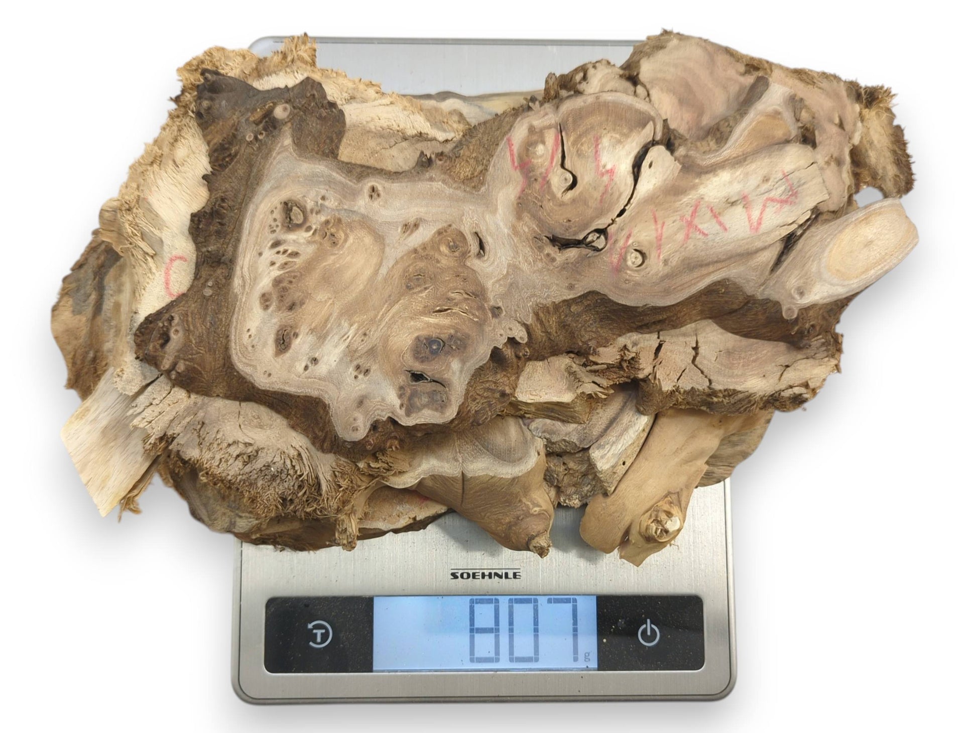 Top-down view of multiple irregular mulberry wood pieces with natural edges on a scale.