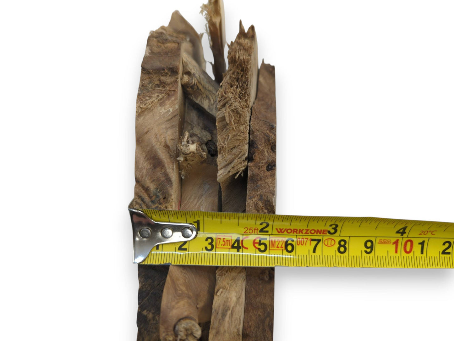 A narrow, rough-cut wood piece with visible grain and texture, measured by a tape.
