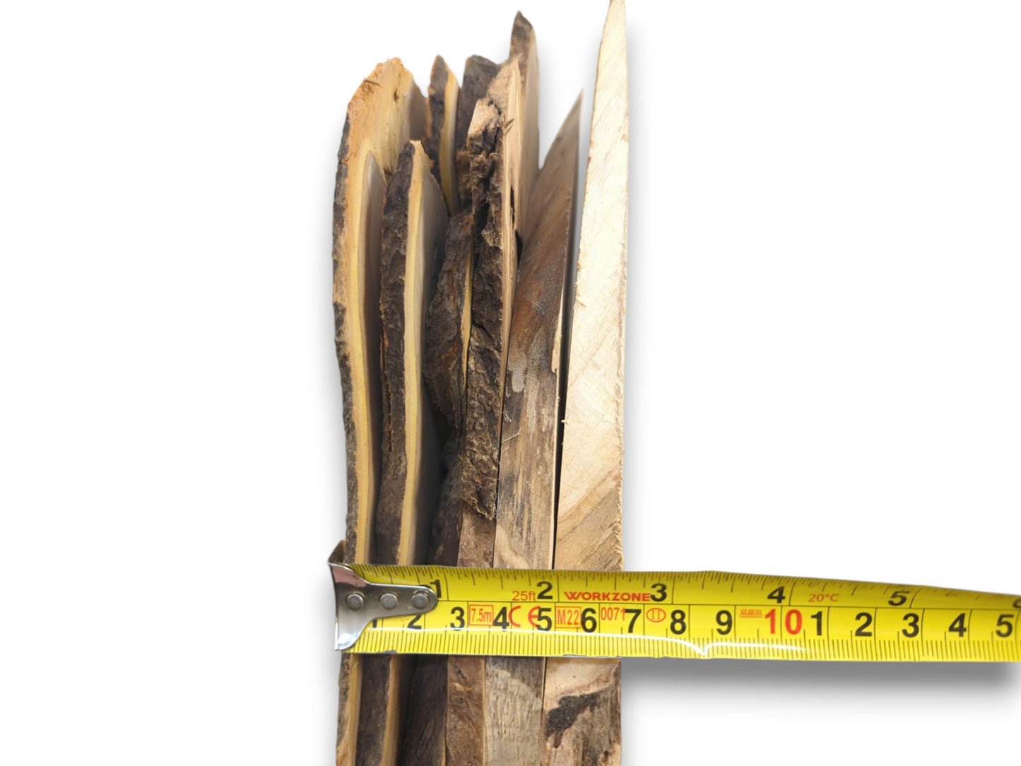 A stack of natural live edge wood slices with bark, measured by a yellow tape.