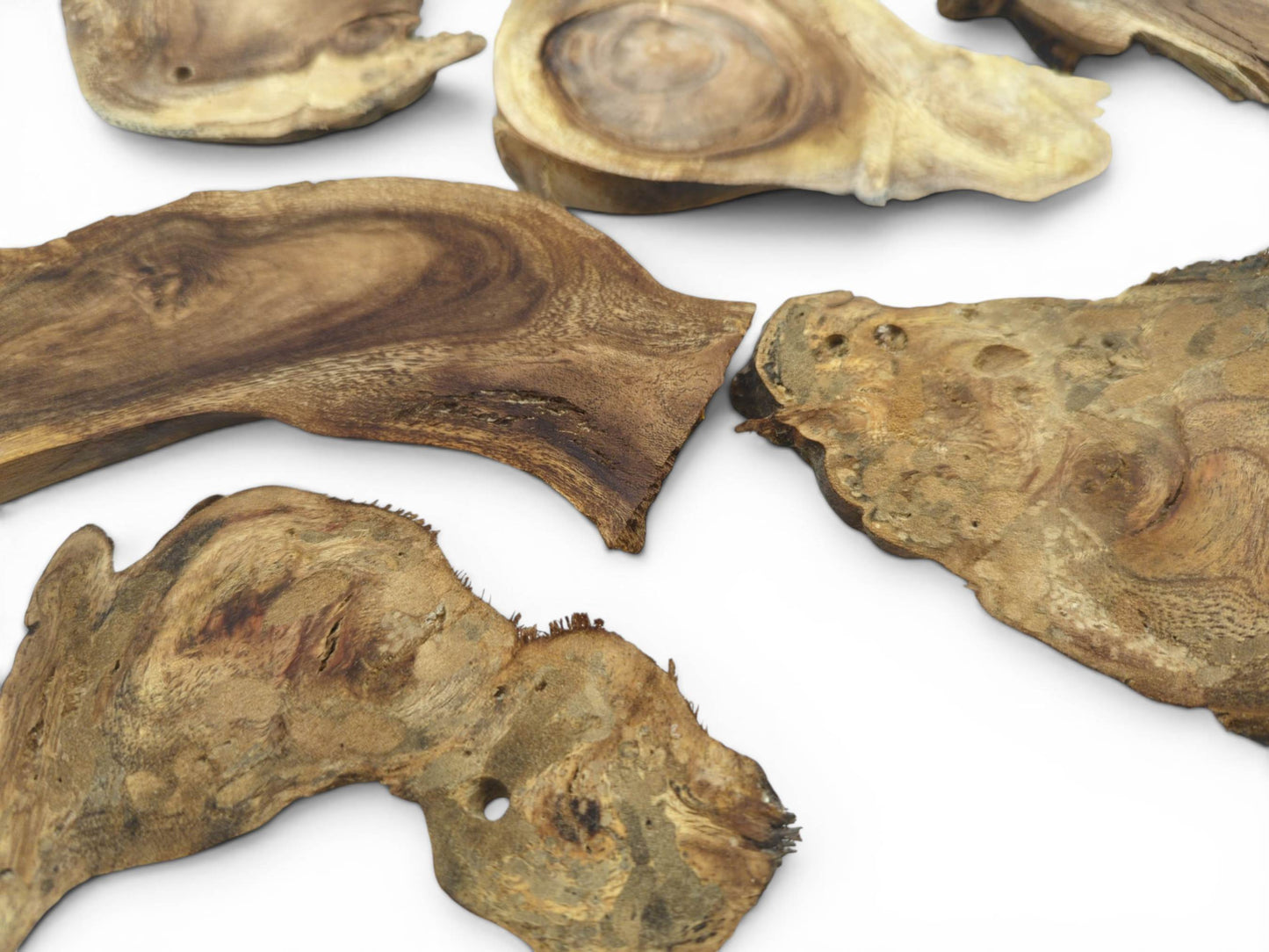 An overhead view of several assorted natural wood pieces with irregular shapes and visible grain.
