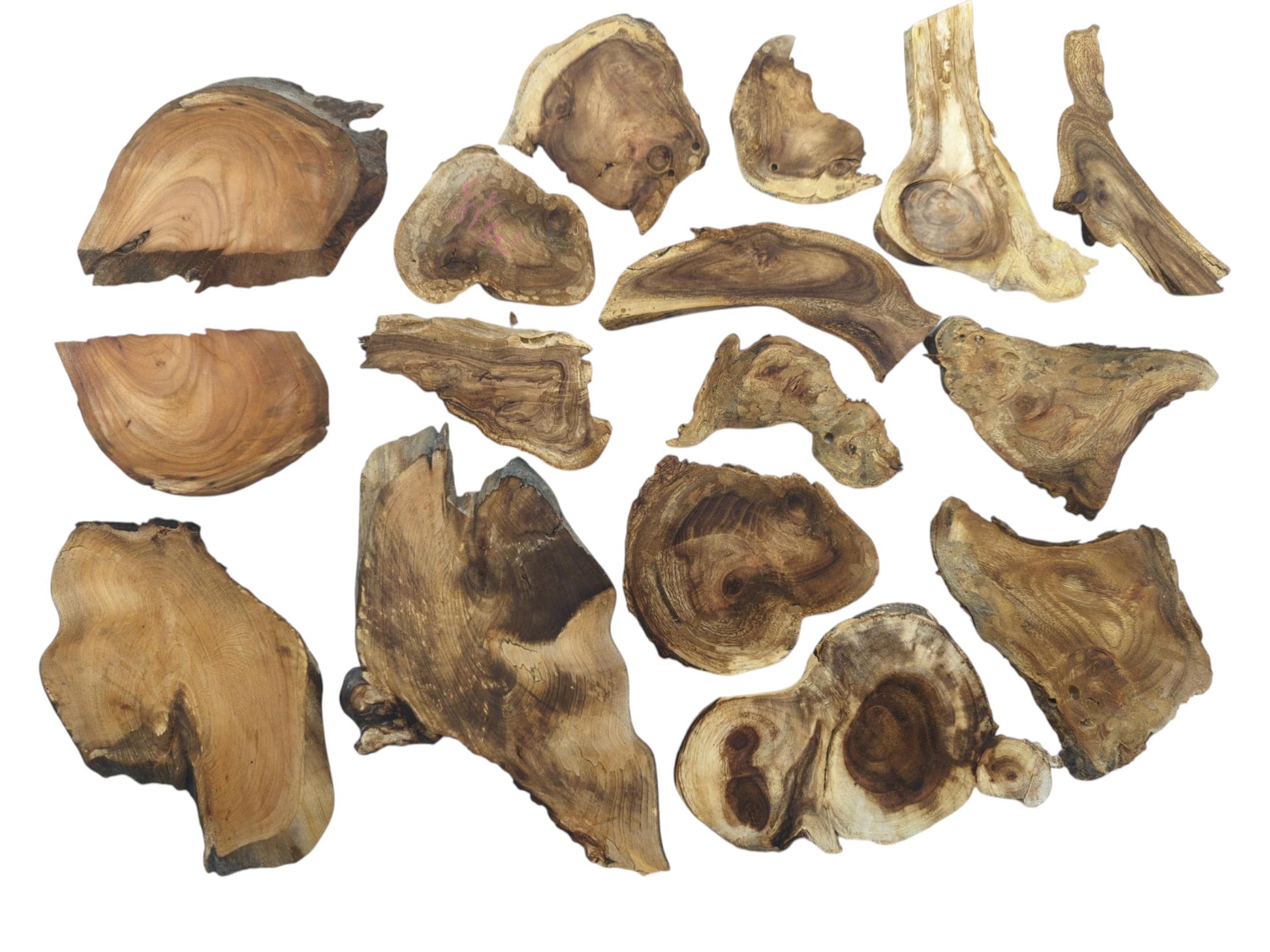 An overhead view of many assorted, irregularly shaped wood pieces with prominent grain and dark knots.